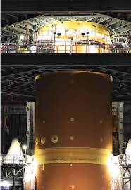 Tripulação da missão Artemis II posando diante do foguete SLS.